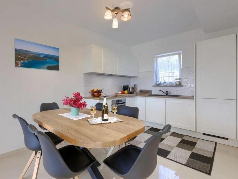 Jedálenský kút s dreveným stolom a otvorenou kuchyňou