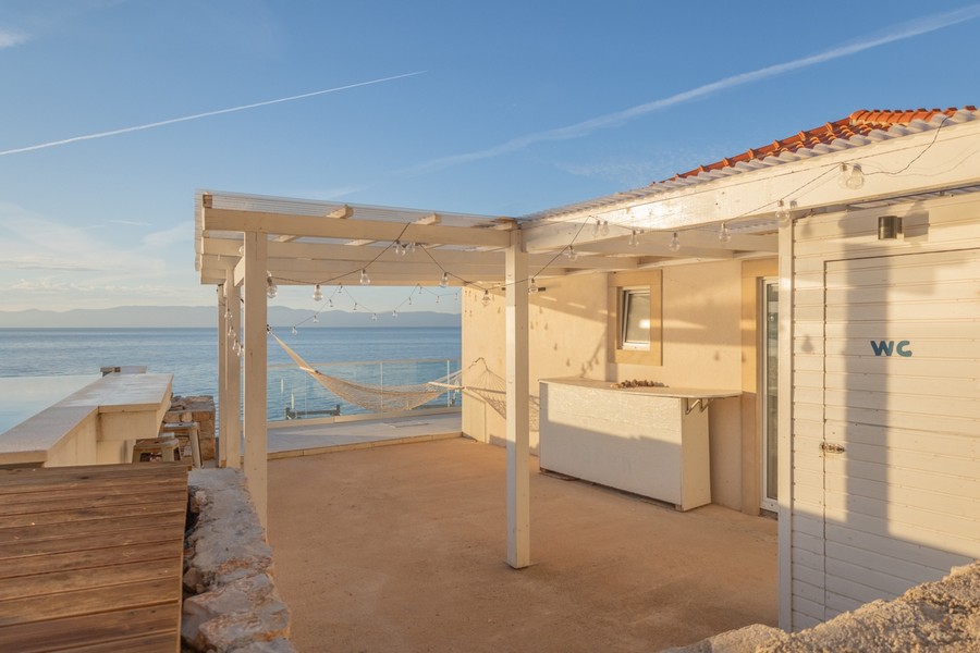 Krytá terasa s vonkajším barom a výhľadom na more