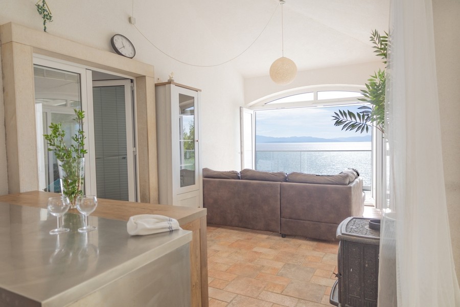 Obývacia izba s veľkým oknom a panoramatickým výhľadom na more
