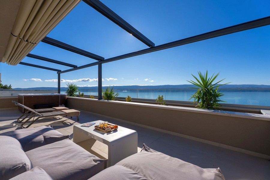 Priestranná terasa s obývacím priestorom a panoramatickým výhľadom na more