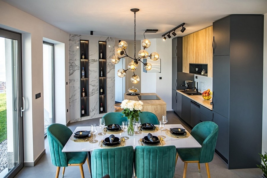 Jedálenský kút s dizajnovou lampou a otvorenou kuchyňou
