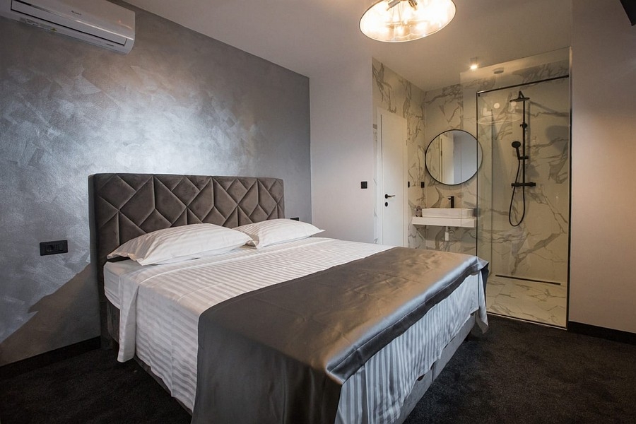 Spálňa s manželskou posteľou a otvorenou kúpeľňou s vlastnou kúpeľňou