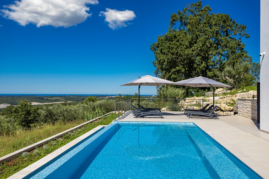 Priestranný bazén so slnečnou terasou a výhľadom na more