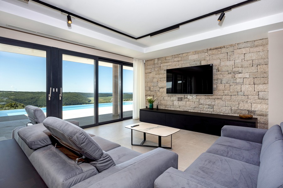 Obývacia izba s panoramatickými oknami a výhľadom do zelene