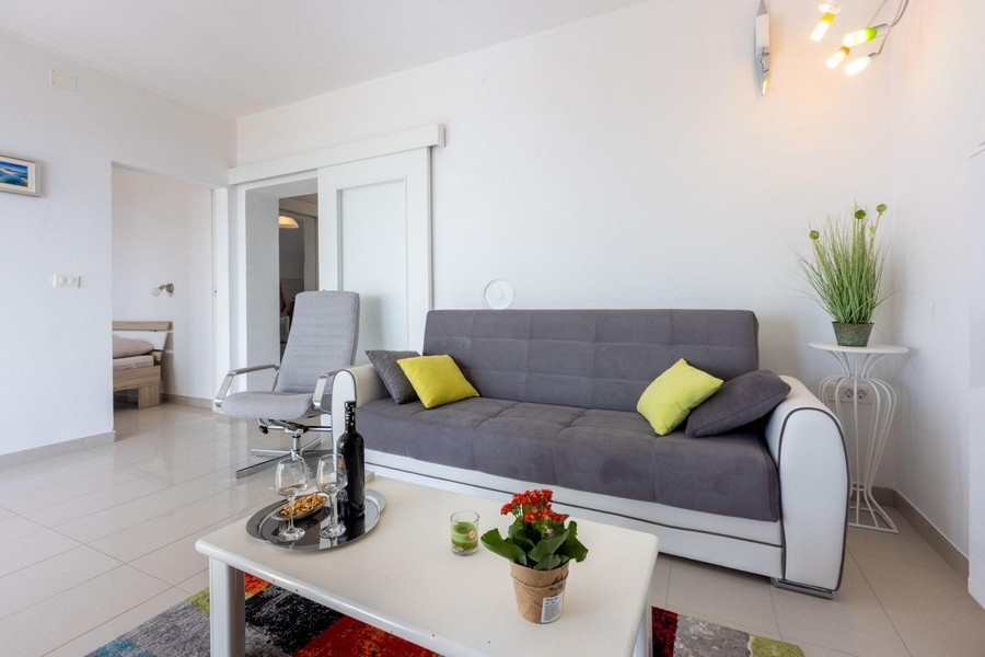 Obývacia izba s pohovkou a otvoreným prístupom do spálne