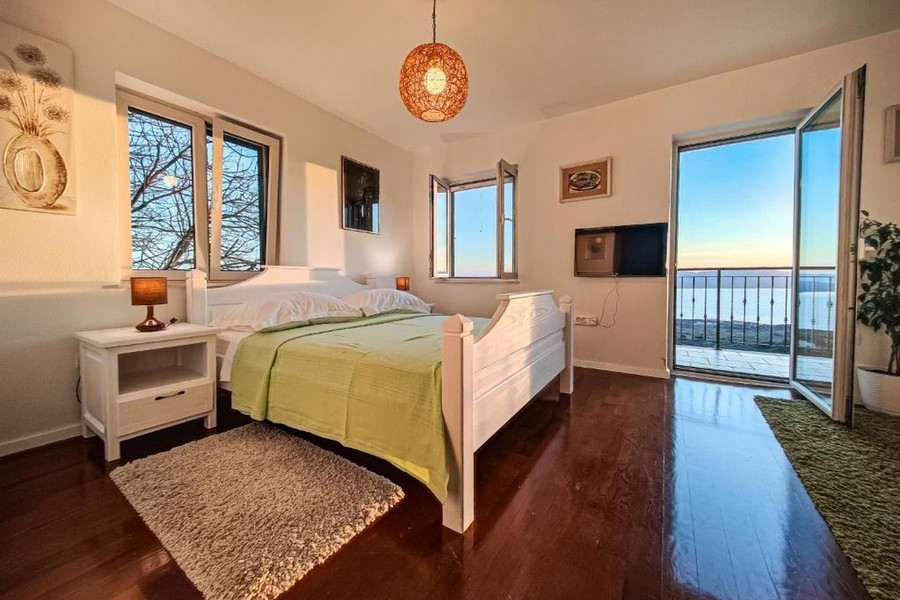 Spálňa s posteľou a výhľadom na more