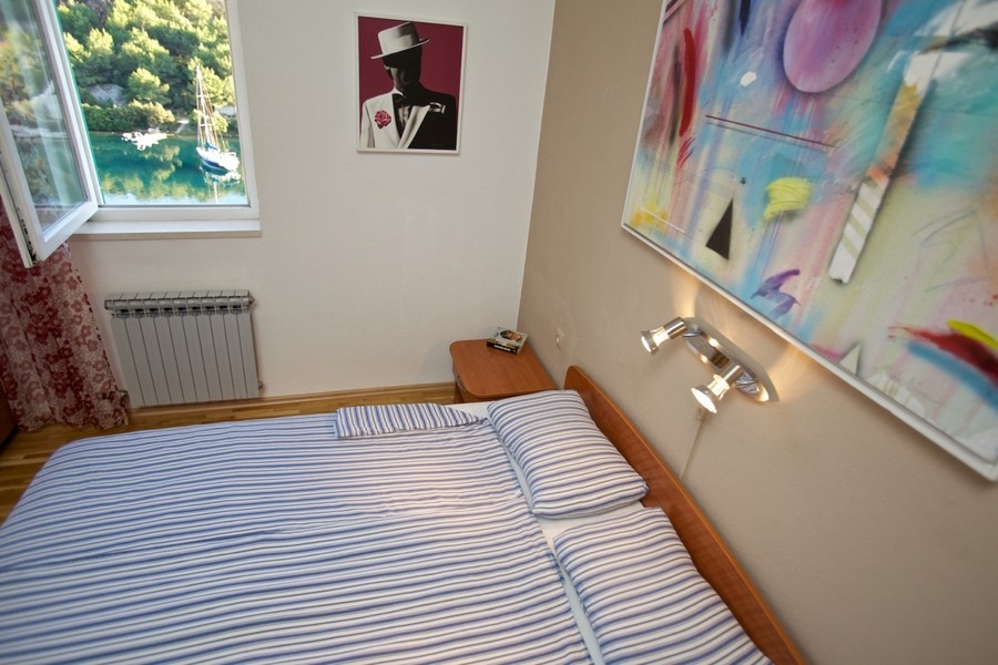 Spálňa s výhľadom z okna na záliv a plachetnicu