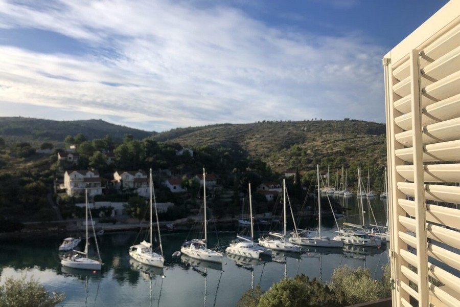 Výhľad na more z balkóna s plachetnicami v zálive