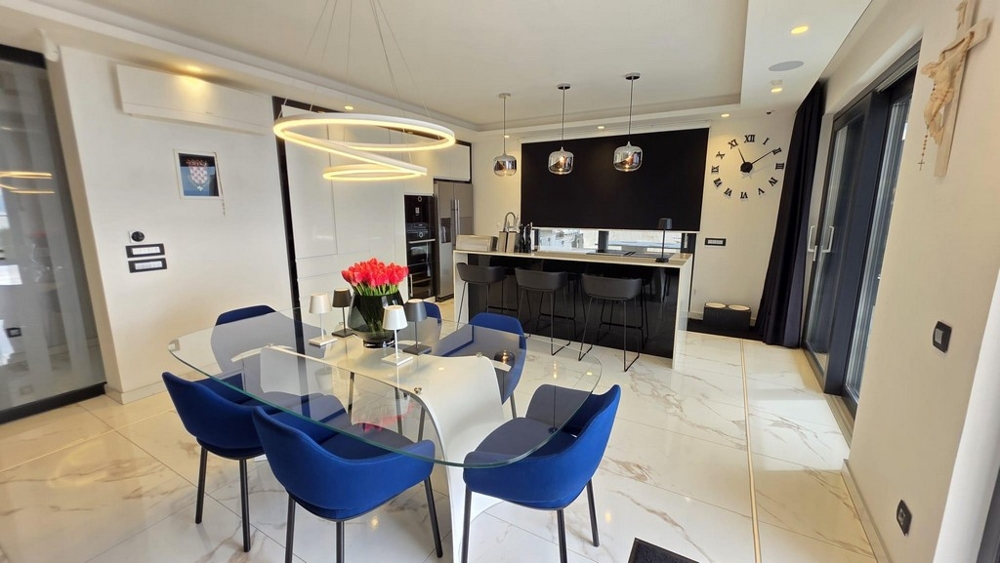 Jedálenský kút so skleneným stolom a modernou kuchyňou