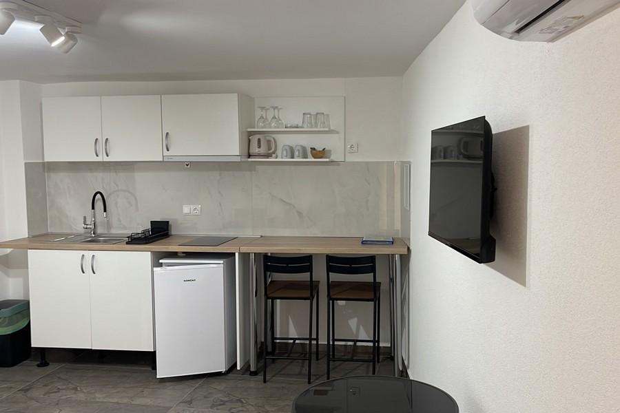 Kuchyňa s barom a TV v apartmáne v Chorvátsku