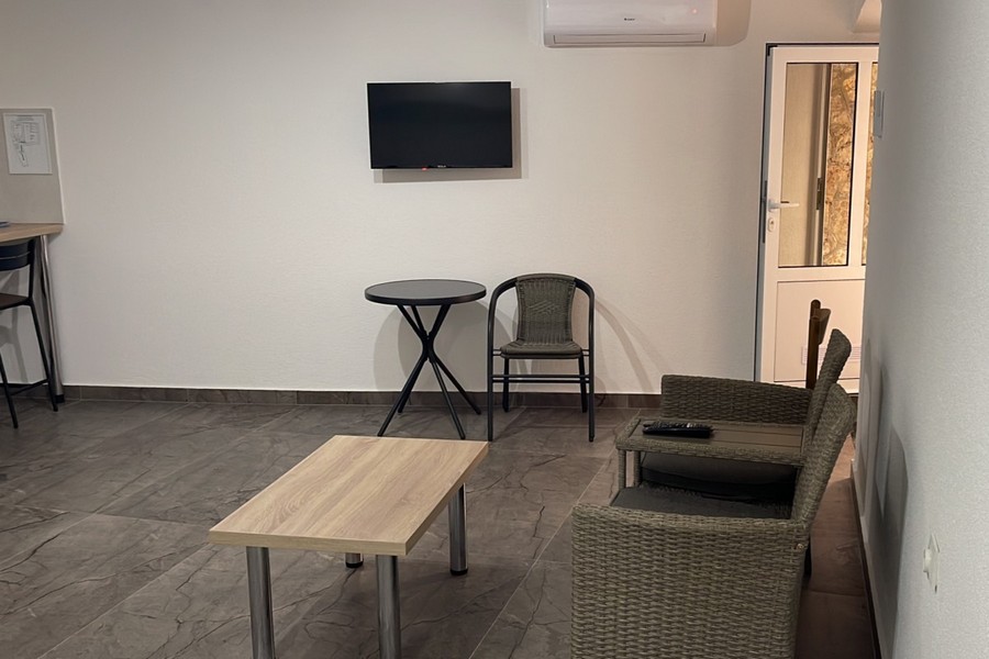 Obývacia časť s kreslom a TV v apartmáne v Chorvátsku