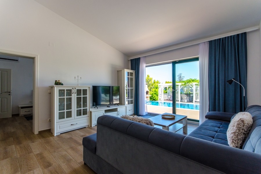 Obývacia izba s výhľadom na terasu a bazén
