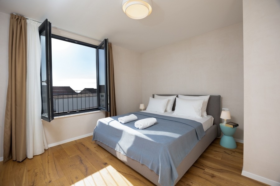 Spálňa s manželskou posteľou a otvoreným oknom