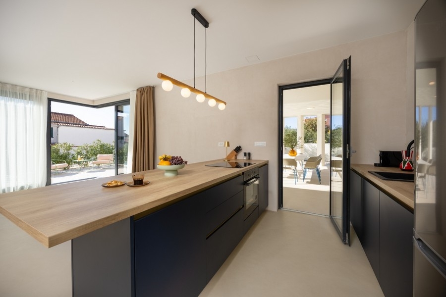 Moderná kuchyňa s ostrovčekom na varenie a vstupom na terasu