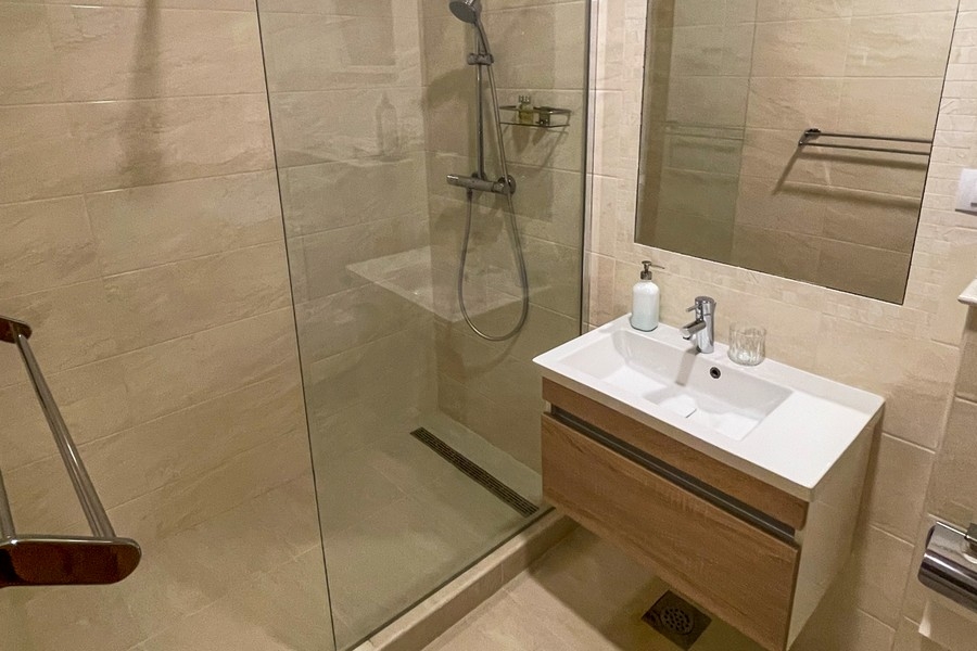 Moderná kúpeľňa so sprchovacím kútom a umývadlom