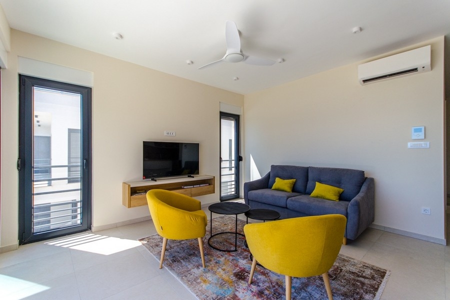 Moderná obývacia izba s klimatizáciou a veľkými oknami s výhľadom na more