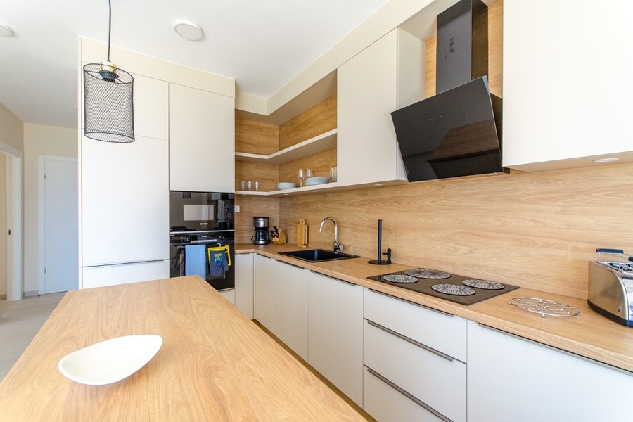 Moderná kuchynská linka so vstavanými spotrebičmi a drevenou pracovnou doskou