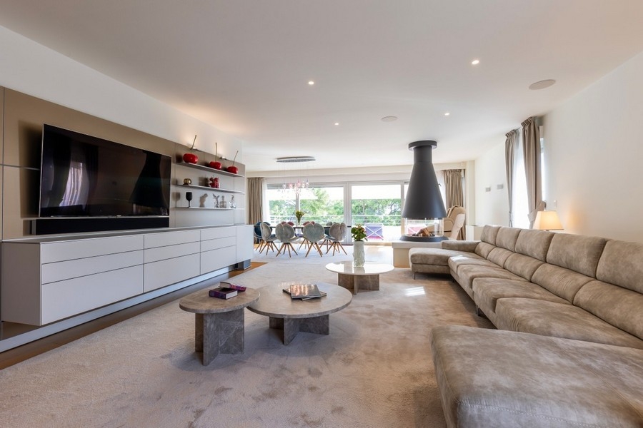 Priestranný obývací priestor s moderným nábytkom a krbom