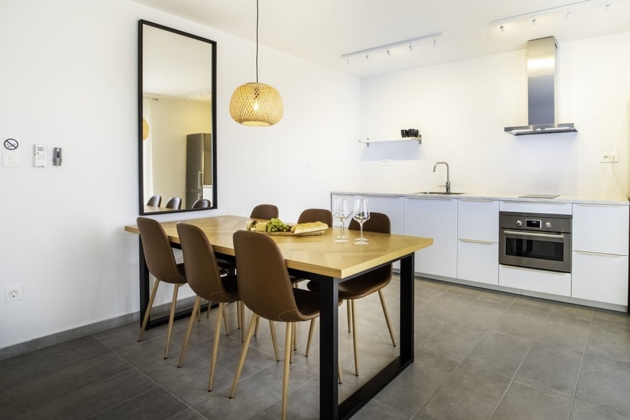 Otvorená kuchyňa s jedálenským stolom a moderne zariadená kuchyňa