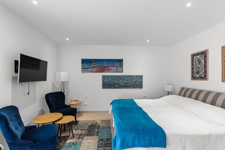 Spálňa s veľkou manželskou posteľou a posedením