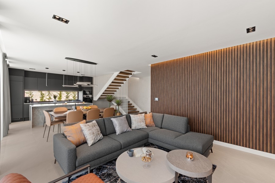 Obývacia izba s dizajnovým nábytkom a otvorenou kuchyňou