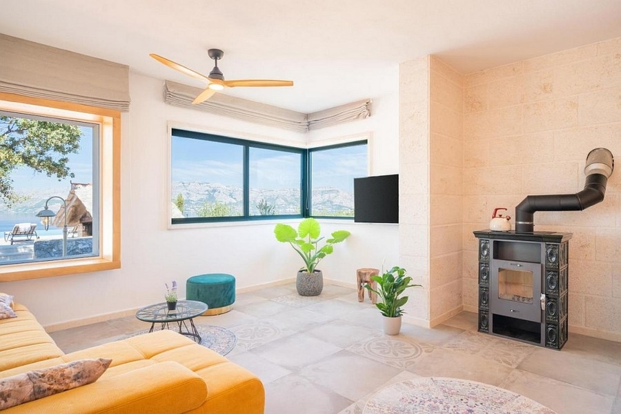 Svetlý obývací priestor s krbom a panoramatickými oknami