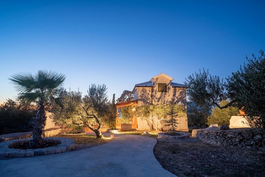 Dalmatínsky dom vo večernej atmosfére s osvetlenou záhradou