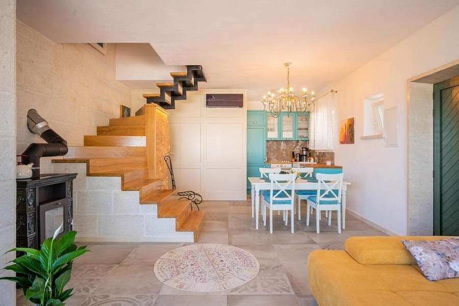 Obývacia izba s otvorenou kuchyňou a schodiskom v dalmatínskom štýle