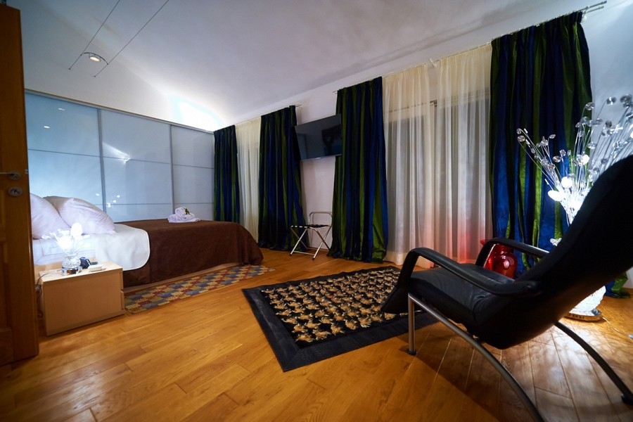 Priestranná spálňa s parketovými podlahami a posedením