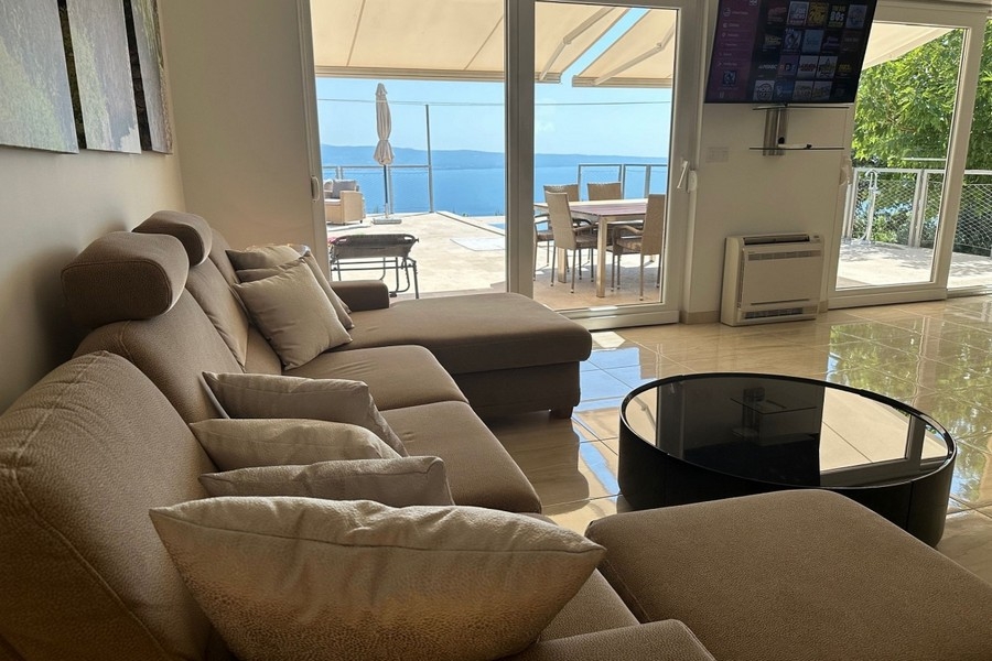 Obývacia izba s prístupom na terasu a výhľadom na more