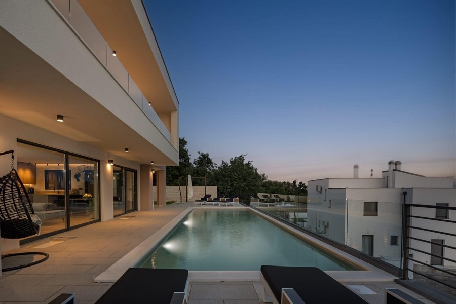 Moderná vila s bazénom s nekonečným okrajom a večerným výhľadom na more