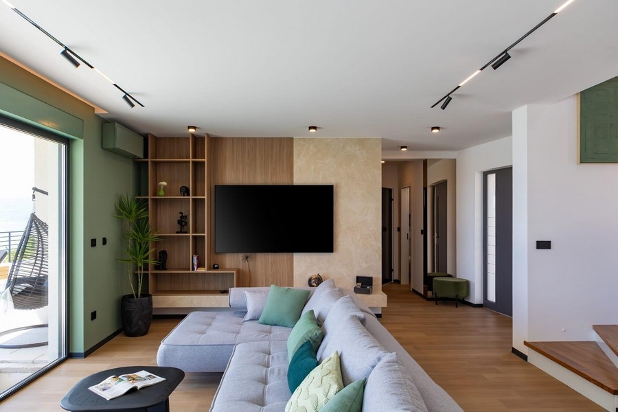 Otvorený obývací priestor s TV stenou a dizajnovým schodiskom