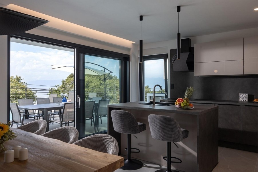 Otvorená kuchyňa s ostrovčekom na varenie a prístupom na terasu