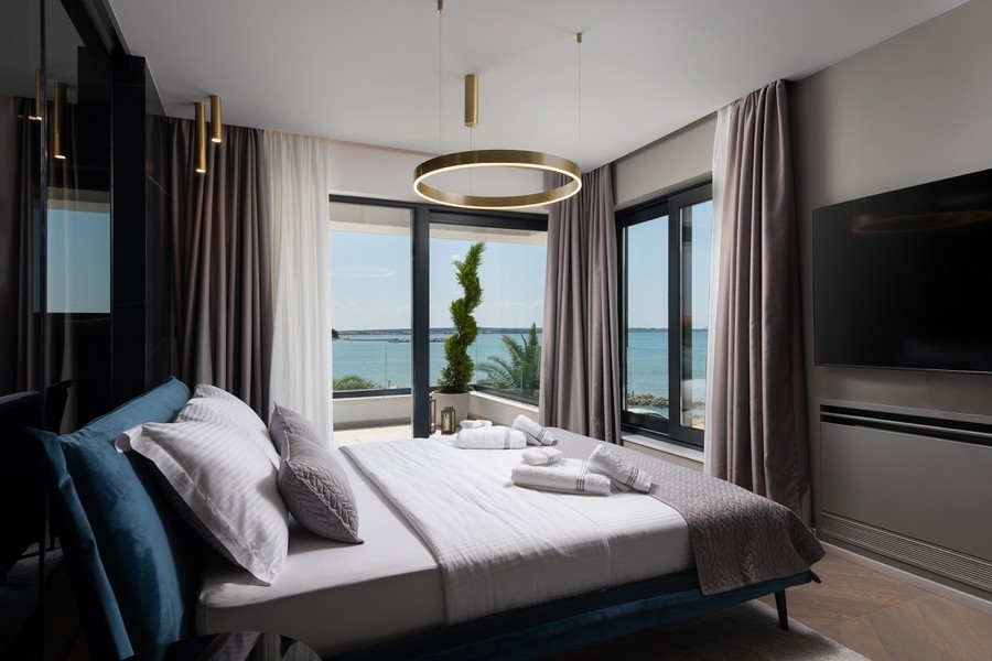 Spálňa s veľkými oknami a výhľadom na more v Chorvátsku