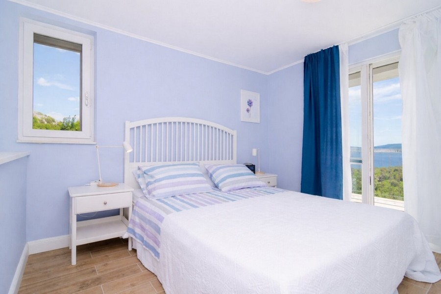 Spálňa s manželskou posteľou a výhľadom na more