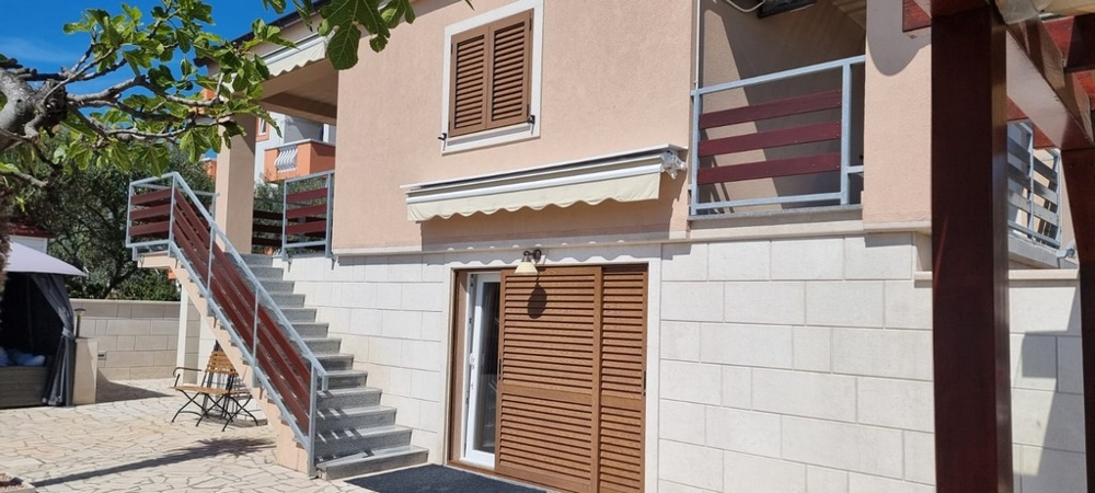 Fasáda domu s balkónom, markízami a samostatnými vstupmi do bytových jednotiek