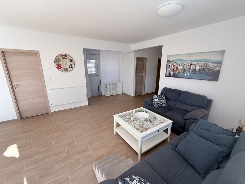 Otvorený obývací priestor s posedením a svetlý interiérový dizajn v dome