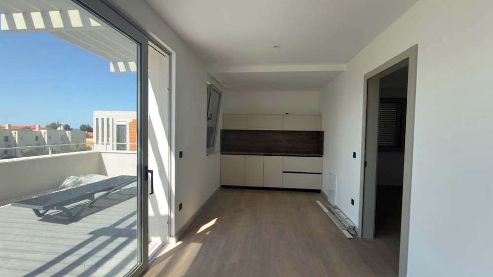 Svetlý obývací priestor s otvorenou kuchyňou a vstupom na terasu