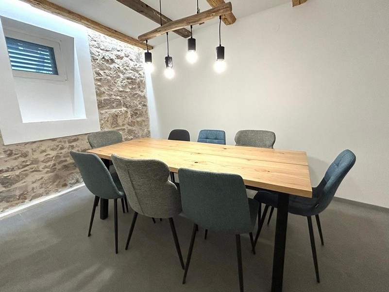 Vnútorný krytý jedálenský kút s drevenými trámami a osvetlením