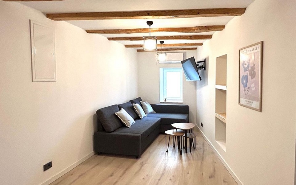 Obývacia izba s pohovkou a trámovým stropom