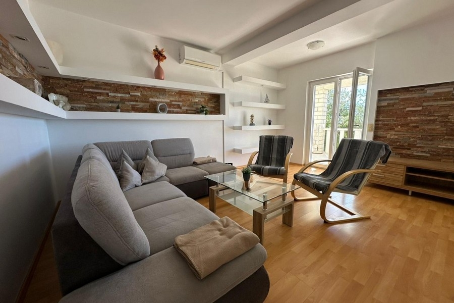 Obývacia izba s pohovkou, kreslom a moderným dizajnom stien