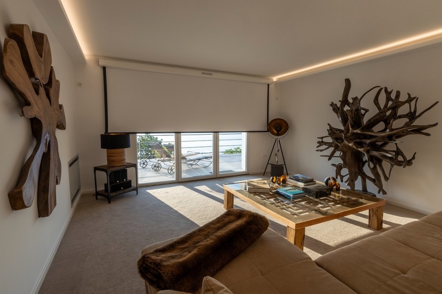 Obývacia izba s veľkými oknami a výhľadom na more