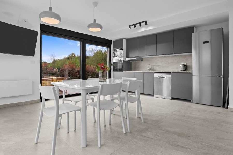 Moderná obývacia a jedálenská časť s otvorenou kuchyňou a prístupom na terasu