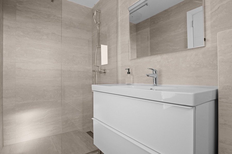 Moderná kúpeľňa so sprchovacím kútom a umývadlom