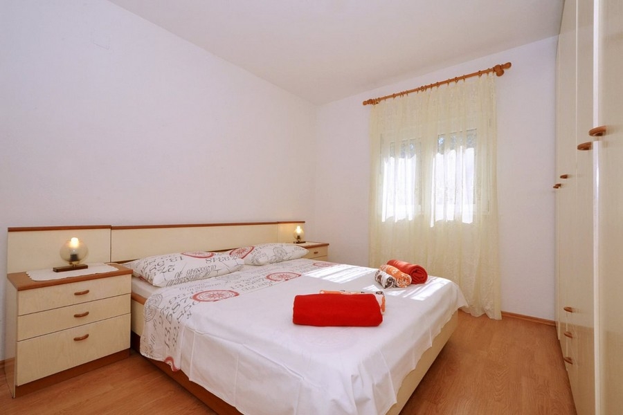 Spálňa s manželskou posteľou a oknom s denným svetlom