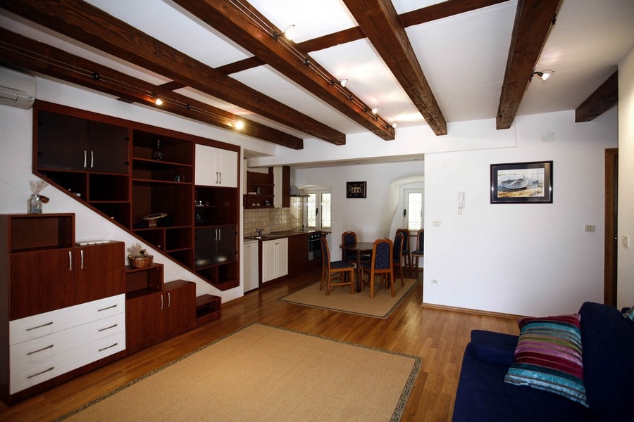Otvorená obývacia izba s vybavenou kuchyňou a dreveným stropom