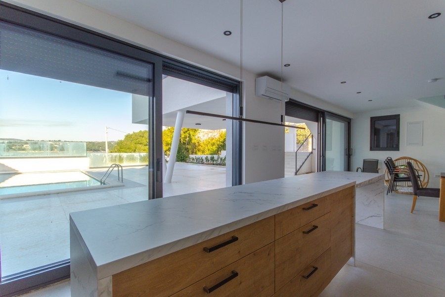 Otvorená kuchyňa s výhľadom na bazén ubytovacieho zariadenia.