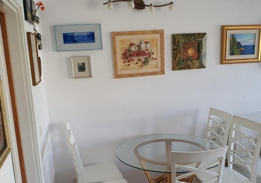 Jedálenský kút s okrúhlym stolom a nástennou dekoráciou