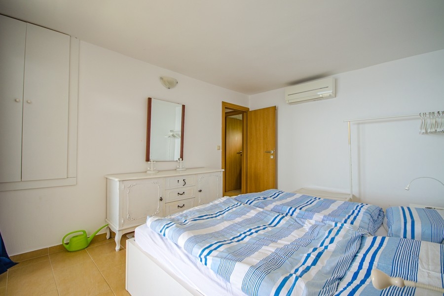 Spálňa s klimatizáciou a jednoduchým nábytkom