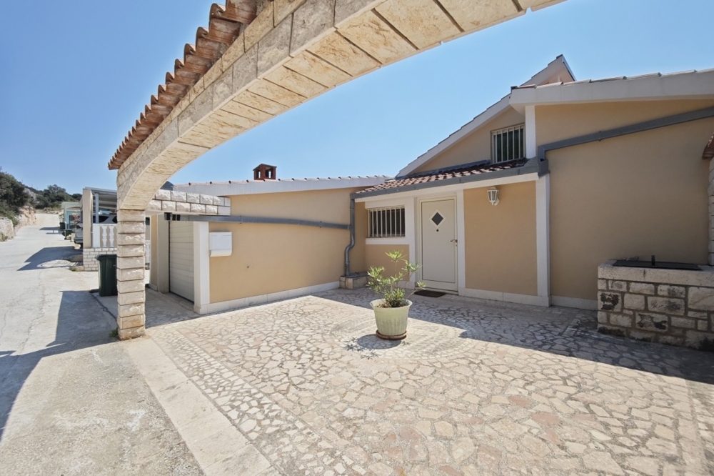 Fasáda domu s garážou a spevneným dvorom